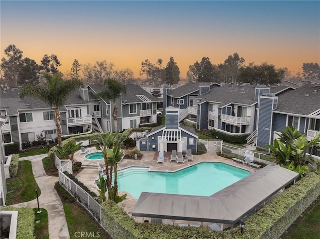 back of house featuring a patio area, a residential view, fence, and a community pool