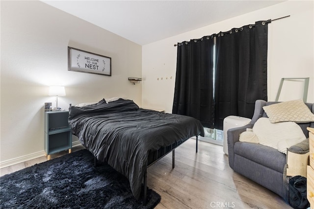 bedroom with baseboards and wood finished floors