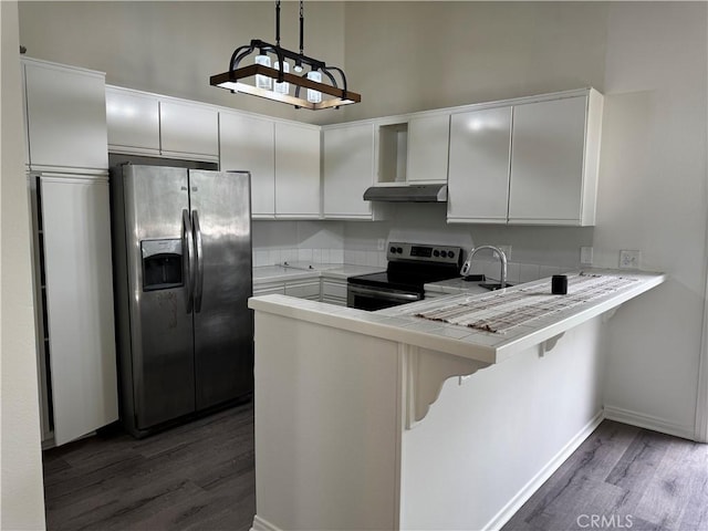 kitchen featuring stainless steel appliances, a peninsula, wood finished floors, and under cabinet range hood