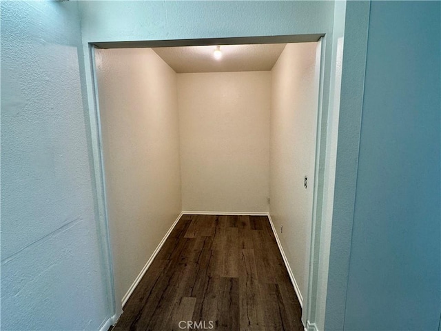 hall with dark wood-style floors and baseboards