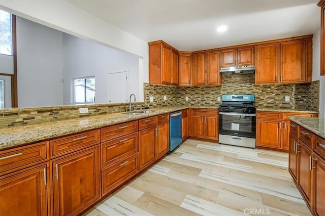 kitchen with light stone countertops, appliances with stainless steel finishes, tasteful backsplash, and sink