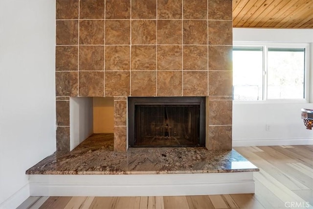 interior details with a tile fireplace and hardwood / wood-style flooring