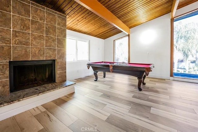 game room with billiards, hardwood / wood-style floors, vaulted ceiling with beams, a tiled fireplace, and wooden ceiling