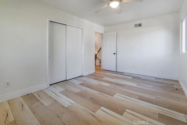 unfurnished bedroom featuring ceiling fan, a closet, and light hardwood / wood-style floors