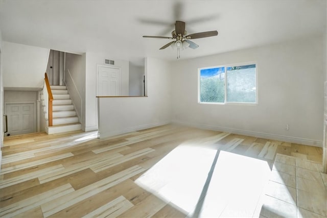 empty room with ceiling fan and light hardwood / wood-style floors