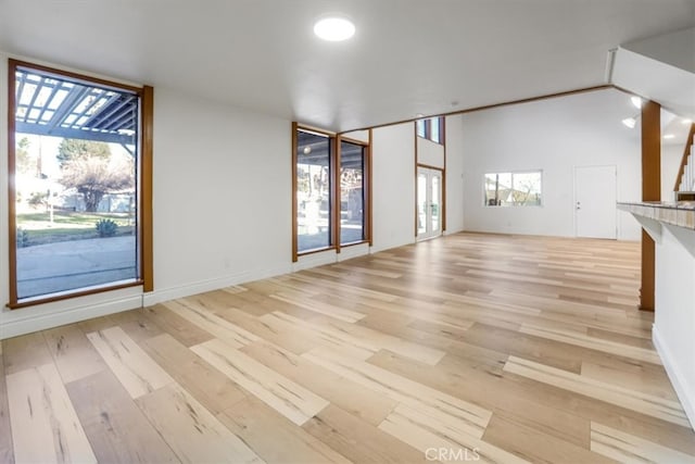 unfurnished living room with a healthy amount of sunlight and light hardwood / wood-style flooring