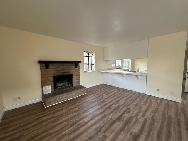 unfurnished living room featuring dark hardwood / wood-style flooring and a fireplace