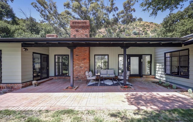 back of house featuring outdoor lounge area and a patio