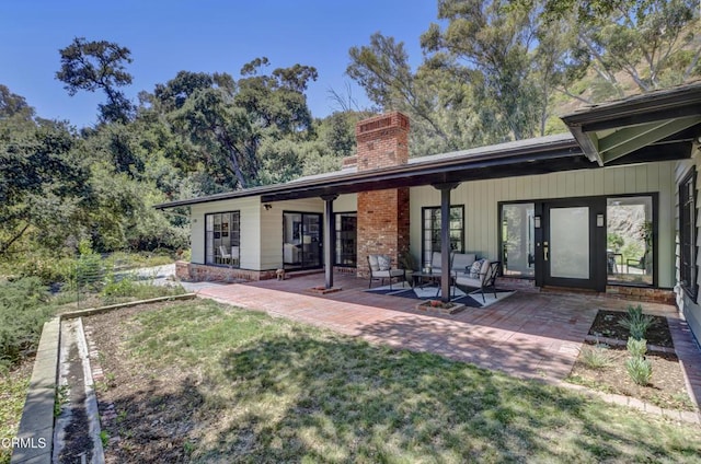 rear view of house with a lawn and a patio area