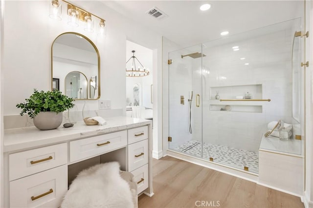 bathroom with hardwood / wood-style flooring, vanity, and a shower with door