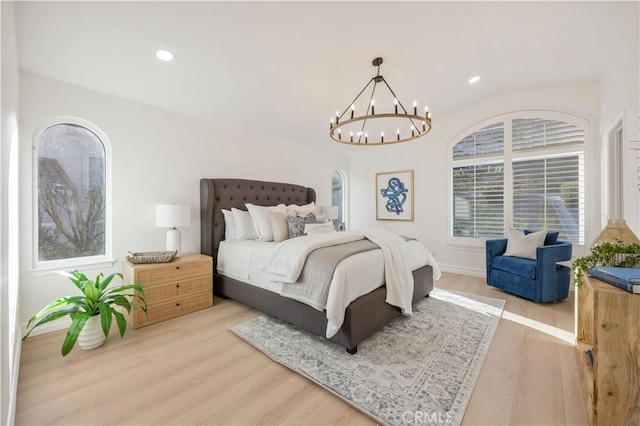 bedroom featuring light wood-type flooring and an inviting chandelier