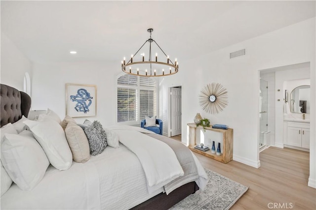 bedroom with ensuite bathroom and light wood-type flooring