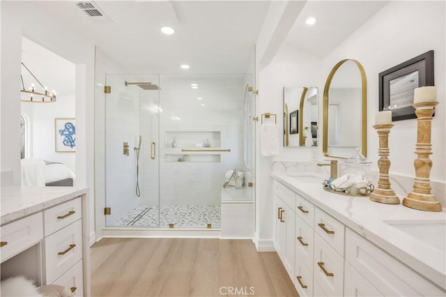 bathroom with hardwood / wood-style flooring, vanity, and a shower with shower door