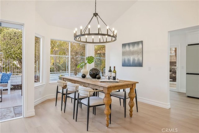 dining area with light wood-type flooring, lofted ceiling, and a healthy amount of sunlight