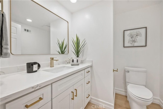 bathroom featuring hardwood / wood-style flooring, vanity, and toilet