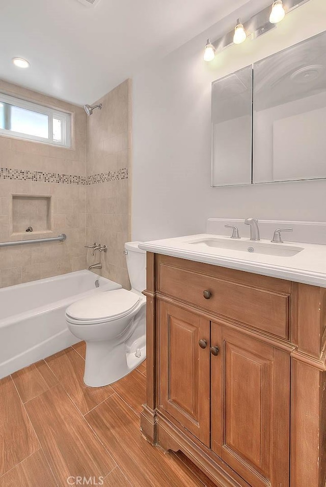 full bathroom with toilet, tiled shower / bath combo, and vanity