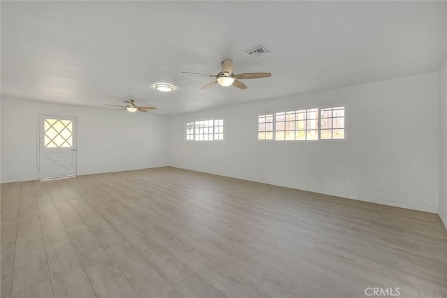 spare room with ceiling fan and light wood-type flooring