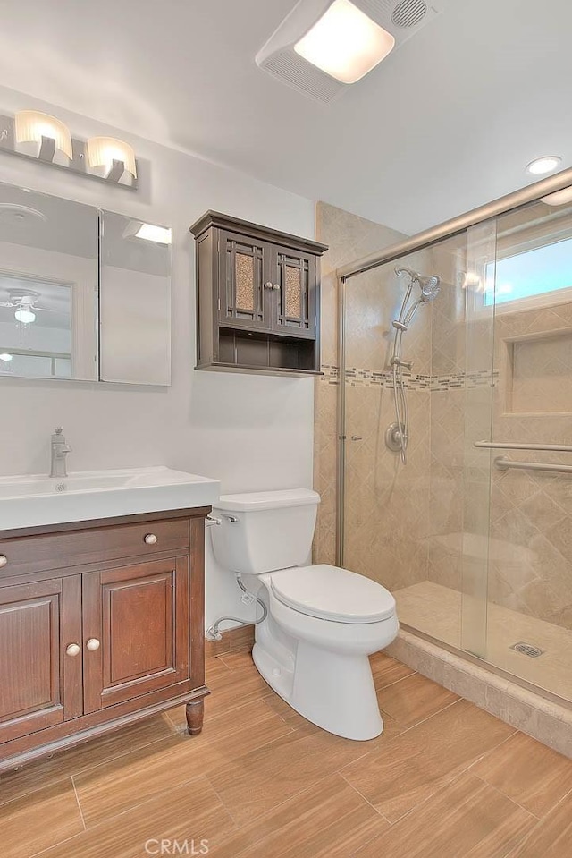 bathroom with walk in shower, vanity, and toilet