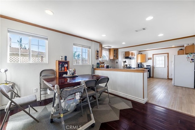 dining space with crown molding and hardwood / wood-style floors