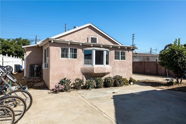 rear view of house with central AC unit and a patio area