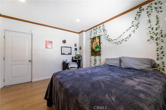 bedroom with crown molding and light wood-type flooring