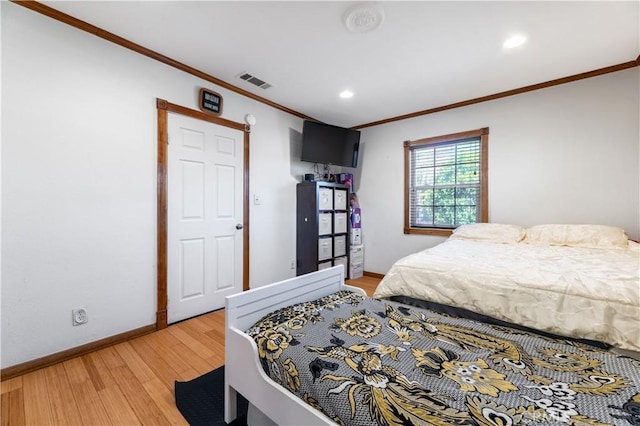 bedroom with hardwood / wood-style floors and crown molding