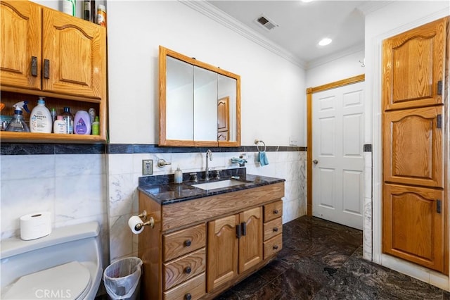 bathroom featuring toilet, vanity, tile walls, and ornamental molding