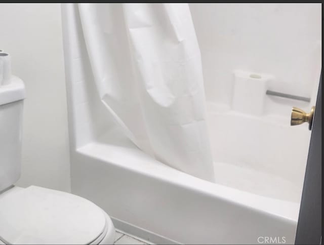 bathroom with shower / tub combo with curtain and toilet