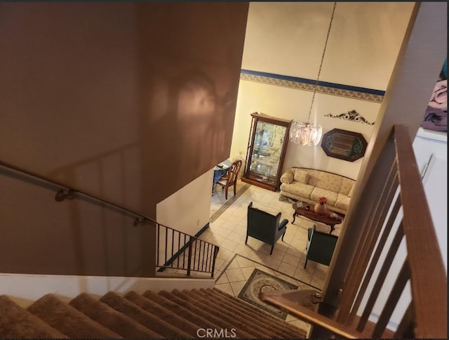 staircase with tile patterned floors and a chandelier