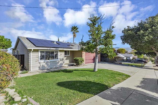 view of front facade with a front yard and solar panels