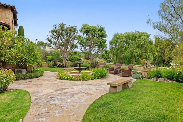 view of community featuring a lawn and a patio area