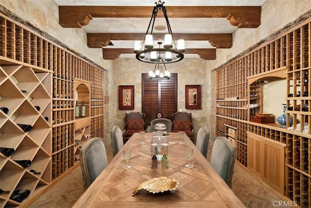 wine cellar featuring beam ceiling, parquet floors, and an inviting chandelier