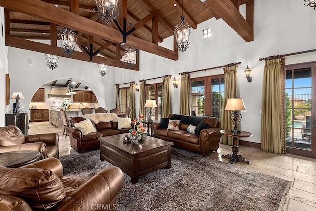 living room with wood ceiling, plenty of natural light, and high vaulted ceiling