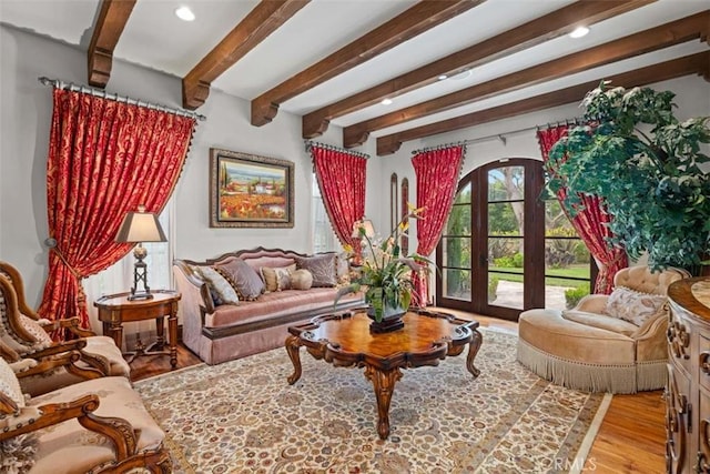 sitting room with light hardwood / wood-style floors, beamed ceiling, and french doors