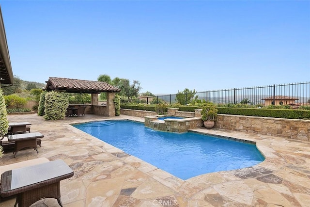 view of swimming pool featuring pool water feature, a patio area, a gazebo, and an in ground hot tub