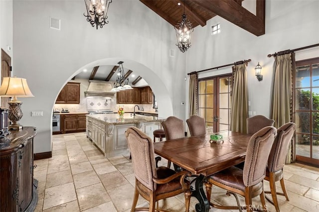 dining area featuring wood ceiling, beamed ceiling, french doors, sink, and high vaulted ceiling