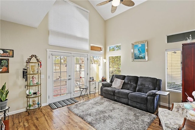 living room with wood-type flooring, ceiling fan, high vaulted ceiling, and french doors