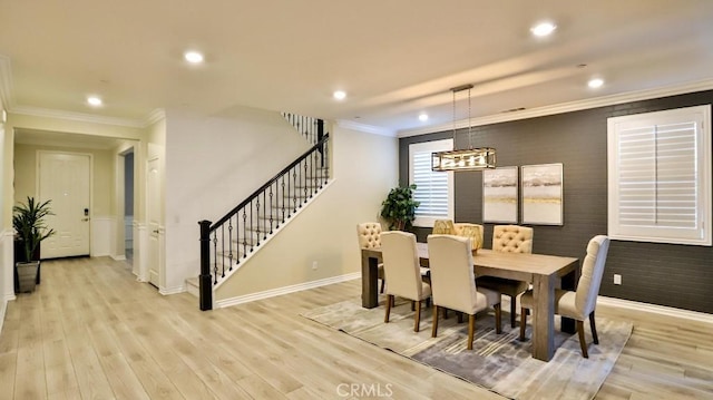 dining area featuring ornamental molding and light hardwood / wood-style floors