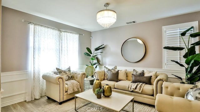 living room featuring light wood-type flooring and a chandelier