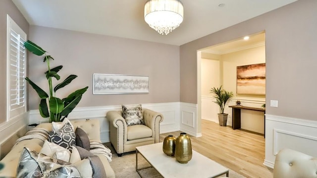 living room with an inviting chandelier, ornamental molding, and hardwood / wood-style floors