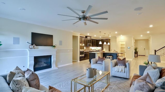 living room with light hardwood / wood-style floors and ceiling fan