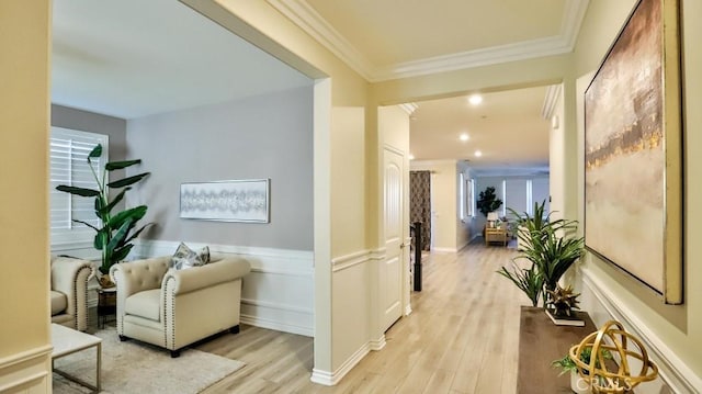 corridor with light hardwood / wood-style flooring and crown molding