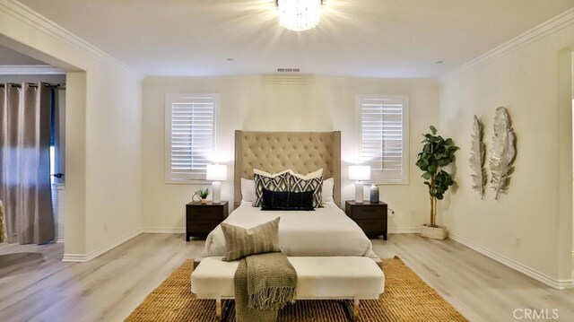 bedroom with light wood-type flooring and crown molding