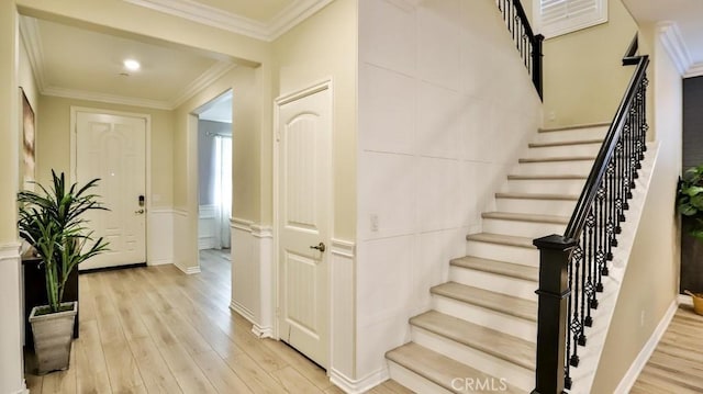 staircase featuring wood-type flooring and ornamental molding