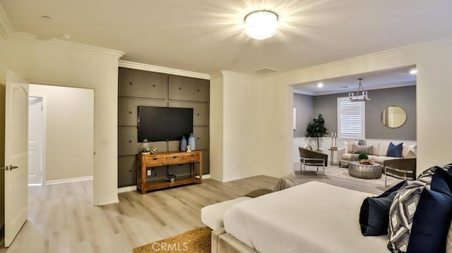 bedroom featuring ornamental molding and light hardwood / wood-style flooring