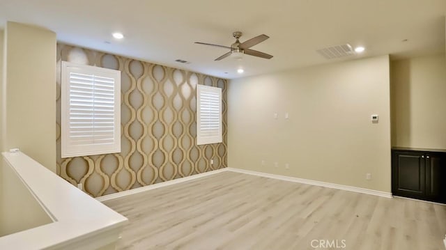 empty room with ceiling fan and hardwood / wood-style flooring