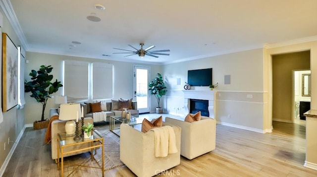 living room with ceiling fan, crown molding, and light hardwood / wood-style floors