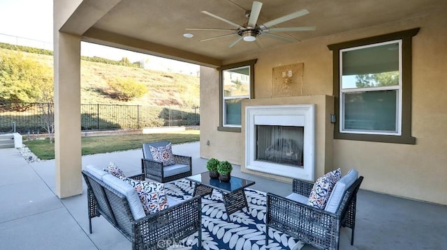 view of patio featuring ceiling fan and an outdoor living space with a fireplace