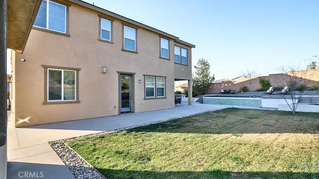 rear view of property with a yard and a patio