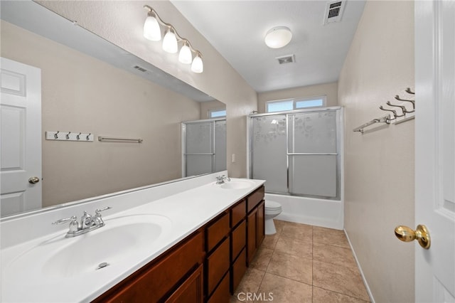 full bathroom featuring tile patterned flooring, enclosed tub / shower combo, vanity, and toilet